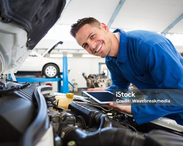 Mechanic using tablet on car at the repair garage